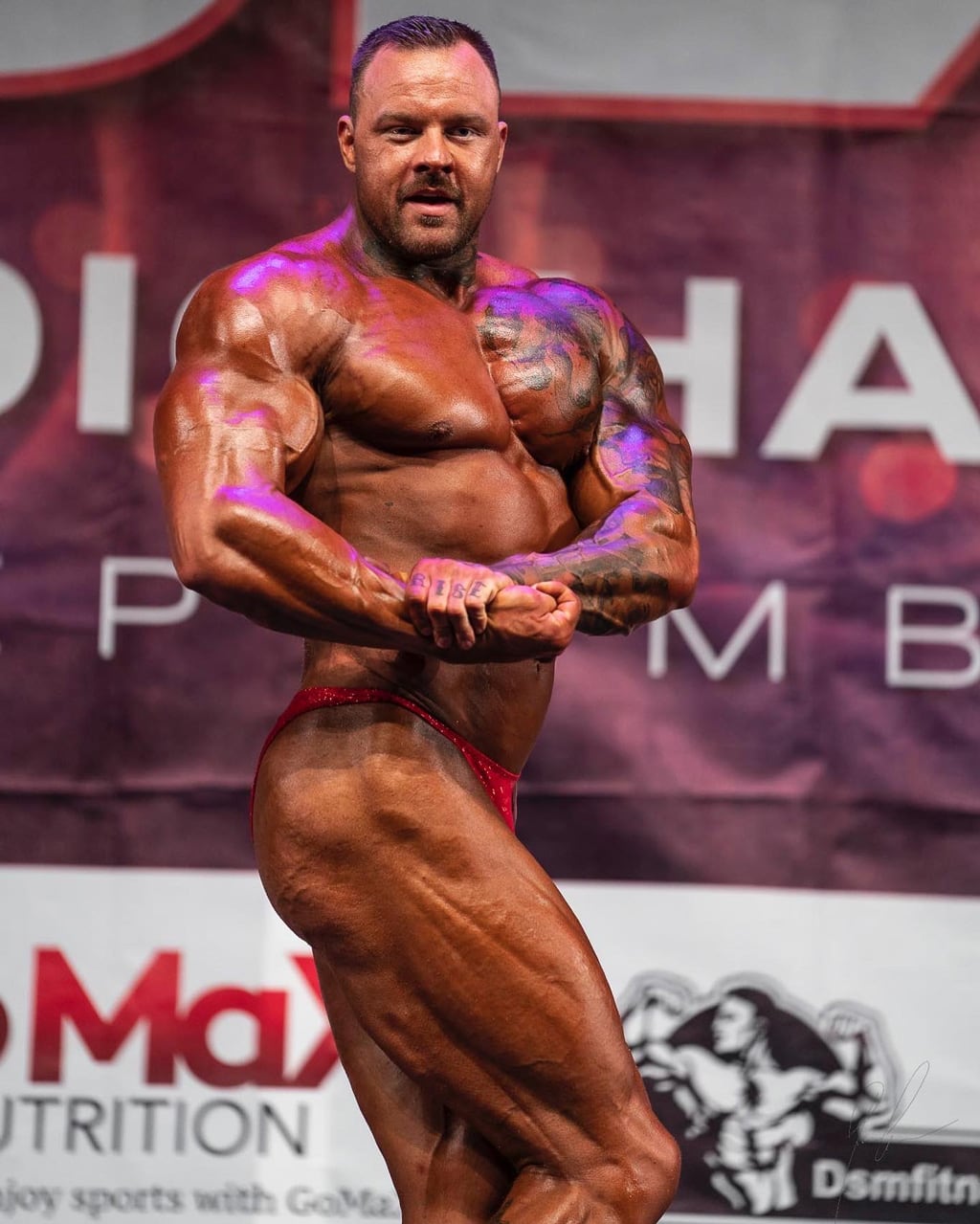 Coach flexer i en bodybuilding konkurranse.